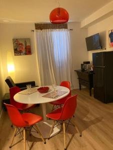 Nova MilaneseCasa Nova Luxury Apartment Suite Limoni的客厅配有带红色椅子的白色桌子