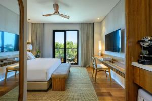 萨法德Cnaan Hotel- Limited Edition By Fattal的一间卧室配有一张床和一张书桌及电视
