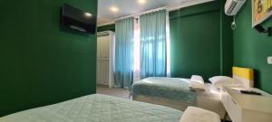 阿拉木图CryptoHotel.Club的一间设有两张床和绿色墙壁的客房