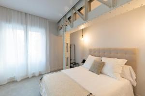 马拉加Diana Suites 23的卧室配有带白色枕头的大床