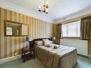 雷丁比奇豪斯酒店的一间卧室配有一张床和镜子