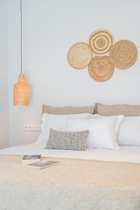 纳克索乔拉Disis Residence的一张带白色枕头和帽子的墙壁床