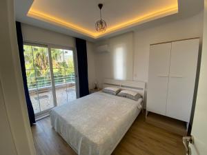 凯麦尔Orange&Lemon Villas Çamyuva的一间卧室设有一张床和一个大窗户