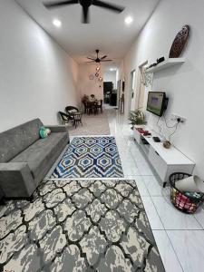 卢穆特Zh homestay teluk batik的带沙发的客厅和用餐室