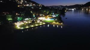 伊塞奥Belvedere Clusane Camping的享有湖泊的夜间美景,配有灯光