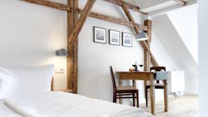 萨勒河畔瑙姆堡大教堂公寓的一间卧室配有一张床、一张桌子和一张桌子