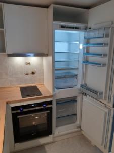 卡拉米洛FeWo Mallorca-ideal - Mercedes的厨房配有空冰箱,门是敞开的