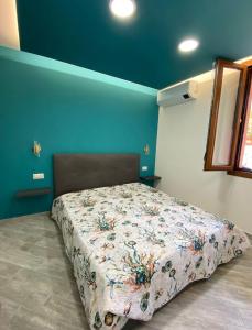 萨萨里Suite GuestHouse a pochi passi dal mare的一间设有床铺的卧室,位于一间拥有蓝色墙壁的房间