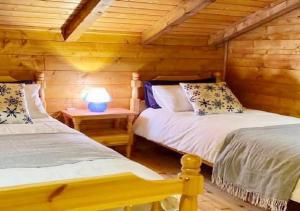林瓜格洛萨Baita Nord的小木屋内一间卧室,配有两张床