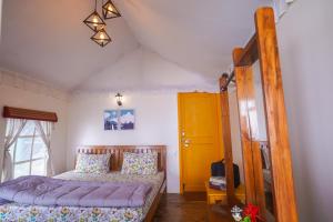 奈尼塔尔Moksham Himalayan Campsite Pangot的一间卧室设有一张床和一个黄色的门