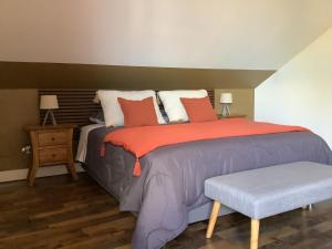 昂特尔德LE JARDIN D'HILAIRE的一间卧室配有一张大床和一张长凳