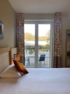 迪南卡斯特德蓬莱斯酒店的一间卧室设有一张床,享有庭院的景色