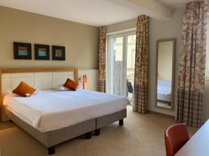 迪南卡斯特德蓬莱斯酒店的一间卧室设有一张大床和一个窗户。