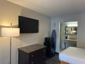 亚历山德里亚Days Inn by Wyndham WestEnd Alexandria,VA Washington DC Area的酒店客房设有一张床和墙上的电视