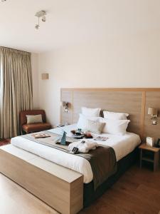 波尔多Hotel Vatel Bordeaux的一间卧室配有一张大床和木制床头板