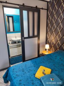拉莫特－伯夫龙Tranquillité & indépendance au coeur de la sologne的一间卧室配有一张蓝色的床、镜子和水槽