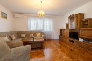 卡什泰拉Apartman Dugeč的带沙发和电视的客厅