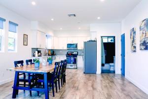 洛杉矶4BR/4BR modern house at Mid-city的厨房配有桌椅和冰箱。