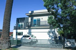 洛杉矶4BR/4BR modern house at Mid-city的前面有一辆汽车停放的白色房子