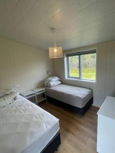 霍尔斯沃德吕尔Stunning house - amazing scenery的一间卧室设有两张床和窗户。