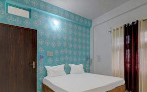 Pura RaghunāthHotel Surya Inn的一间卧室设有一张床和蓝色的墙壁