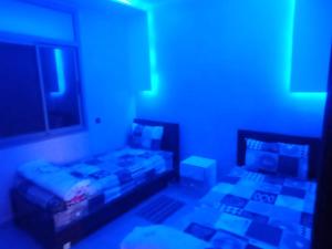 GourizimDisney land villa的一间设有两张床和蓝色灯光的房间