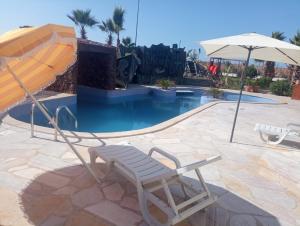 GourizimDisney land villa的游泳池旁的椅子和遮阳伞