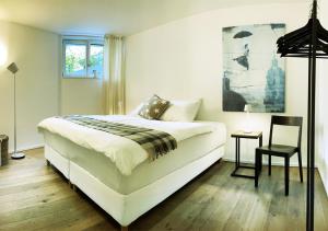 苏黎世Stay at Night - Moonlight的卧室配有一张白色大床和一把椅子
