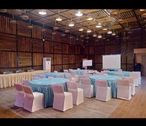 瓦拉纳西PRIME LAND的大房间设有蓝色的桌子和白色的椅子