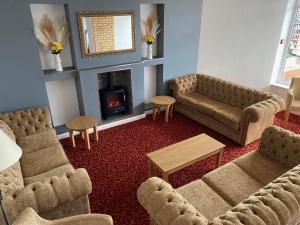 布里德灵顿君主酒店的客厅设有两张沙发和一个壁炉