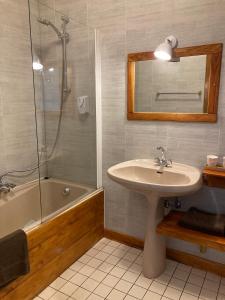 克吕特法国奥贝格酒店的浴室配有水槽、淋浴和浴缸。