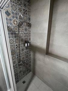 三星乡微困旅宿的一间带淋浴的浴室和瓷砖墙