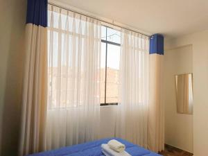 利马A y J Familia Hospedaje的一间卧室配有床和带窗帘的窗户