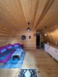 梅斯蒂亚Cottage Mida的客厅设有紫色沙发和木制天花板