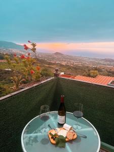 拉奥罗塔瓦Sun-soaked apt w patio, balcony & garden - Aguilas的一张桌子,上面放着两杯酒和一瓶葡萄酒