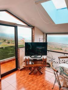 拉奥罗塔瓦Sun-soaked apt w patio, balcony & garden - Aguilas的客厅设有大电视和大窗户
