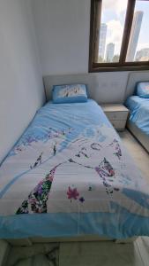 Bene BeraqNew Stylish Apartment with Balcony Close to Tel Aviv的一张带鲜花的蓝色棉被的床