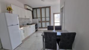 Bene BeraqNew Stylish Apartment with Balcony Close to Tel Aviv的厨房配有冰箱和桌椅