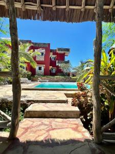 瓦塔穆Manasha Apartment 1的一座带游泳池和红色建筑的度假村