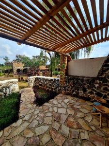 姆巴拉拉GKAT Resort的一个带木制凉亭的石头庭院