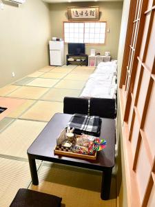 大阪Wafu Ryokan Uehonmachi的客厅配有桌子和床。