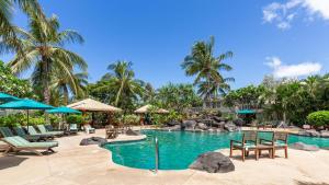 卡波雷Ko Olina Kai New Villa Ohana的度假村的游泳池,配有椅子和遮阳伞