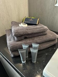 奥尔什丁Apartament Sikorskiego Olsztyn - NAJLEPSZY WIDOK的一张桌子,上面有三杯眼镜、毛巾和盒子