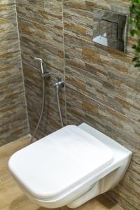 沃洛斯Bardis Hidden Gem的浴室设有白色卫生间和砖墙