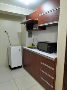 利马Lugar cómodo y seguro的一间带微波炉和冰箱的小厨房