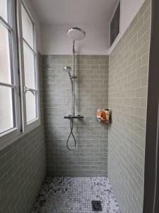 巴黎Home sweet home的浴室铺有绿色瓷砖,设有淋浴。