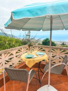 拉奥罗塔瓦Sun-soaked apt w patio, balcony & garden - Aguilas的阳台的遮阳伞下的桌椅