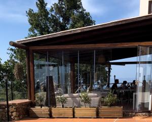 吉泽里亚Casale Calabria的餐厅设有玻璃墙,客人坐在桌子旁
