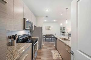 坦帕Lavish 2BR Apartment in Tampa的厨房配有不锈钢用具,铺有木地板