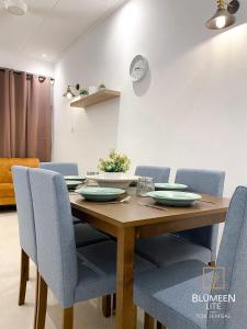 瓜拉丁加奴Blumeen Lite 1 - Comfortable Budget Home 3BR的一间带木桌和蓝色椅子的用餐室